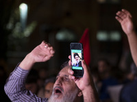 An Iranian protester holds his cellphone featuring a portrait of Lebanon's Hezbollah Secretary General, Hassan Nasrallah, during a protest g...