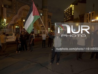 An Iranian protester waves a Palestinian flag while shouting anti-Israeli and anti-U.S. slogans during a protest gathering to condemn an Isr...