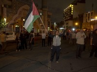 An Iranian protester waves a Palestinian flag while shouting anti-Israeli and anti-U.S. slogans during a protest gathering to condemn an Isr...