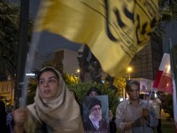 A veiled Iranian protester holds a portrait of Iran's Supreme Leader, Ayatollah Ali Khamenei, while taking part in a protest gathering to co...