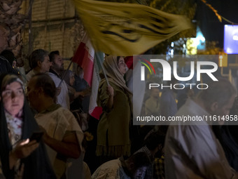 An Iranian female protester waves a flag while taking part in a protest gathering to condemn an Israeli air strike against Lebanon in Tehran...