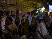 An Iranian female protester waves a flag while taking part in a protest gathering to condemn an Israeli air strike against Lebanon in Tehran...