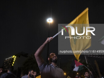 An Iranian protester waves a flag of Lebanon's Hezbollah while taking part in a protest gathering to condemn an Israeli air strike against L...