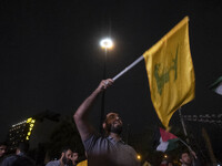 An Iranian protester waves a flag of Lebanon's Hezbollah while taking part in a protest gathering to condemn an Israeli air strike against L...