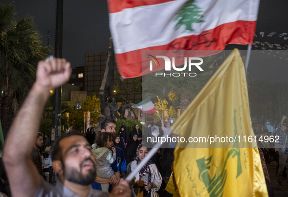 An Iranian protester waves a flag of Lebanon's Hezbollah while shouting anti-Israeli and anti-U.S. slogans during a protest gathering to con...