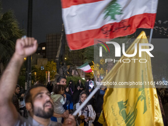 An Iranian protester waves a flag of Lebanon's Hezbollah while shouting anti-Israeli and anti-U.S. slogans during a protest gathering to con...