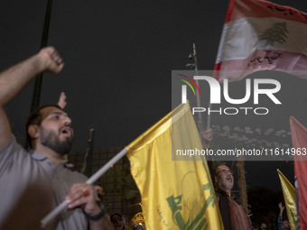 An Iranian protester waves a flag of Lebanon's Hezbollah while shouting anti-Israeli and anti-U.S. slogans during a protest gathering to con...