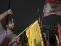 An Iranian protester waves a flag of Lebanon's Hezbollah while shouting anti-Israeli and anti-U.S. slogans during a protest gathering to con...