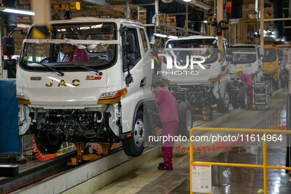 Workers work on a vehicle assembly line at a light truck workshop of Anhui Jianghuai Automobile Group Co LTD in Hefei, China, on September 2...