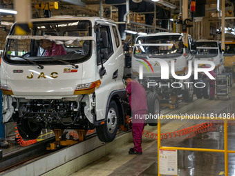 Workers work on a vehicle assembly line at a light truck workshop of Anhui Jianghuai Automobile Group Co LTD in Hefei, China, on September 2...