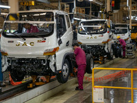 Workers work on a vehicle assembly line at a light truck workshop of Anhui Jianghuai Automobile Group Co LTD in Hefei, China, on September 2...