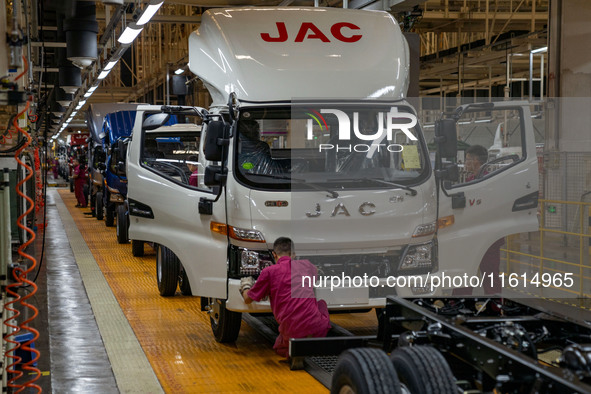 Workers work on a vehicle assembly line at a light truck workshop of Anhui Jianghuai Automobile Group Co LTD in Hefei, China, on September 2...