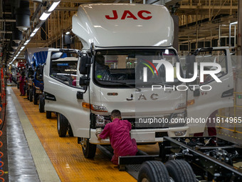 Workers work on a vehicle assembly line at a light truck workshop of Anhui Jianghuai Automobile Group Co LTD in Hefei, China, on September 2...