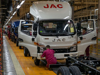 Workers work on a vehicle assembly line at a light truck workshop of Anhui Jianghuai Automobile Group Co LTD in Hefei, China, on September 2...