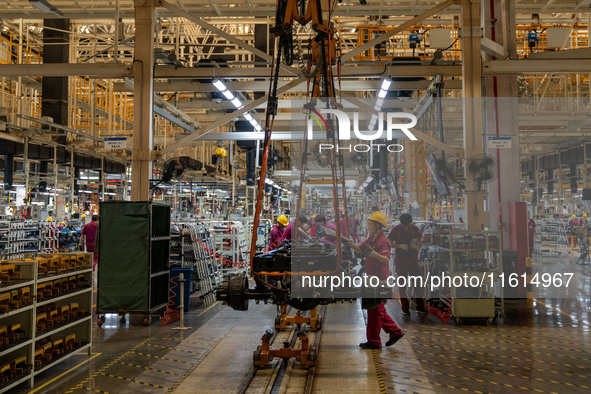 Workers work on a vehicle assembly line at a light truck workshop of Anhui Jianghuai Automobile Group Co LTD in Hefei, China, on September 2...