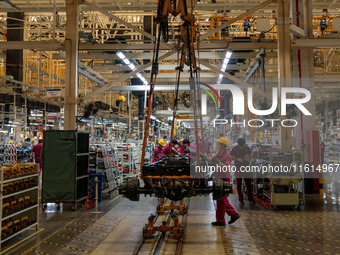 Workers work on a vehicle assembly line at a light truck workshop of Anhui Jianghuai Automobile Group Co LTD in Hefei, China, on September 2...