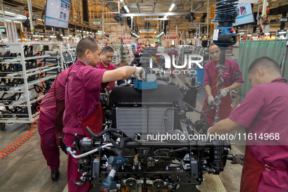 Workers work on a vehicle assembly line at a light truck workshop of Anhui Jianghuai Automobile Group Co LTD in Hefei, China, on September 2...