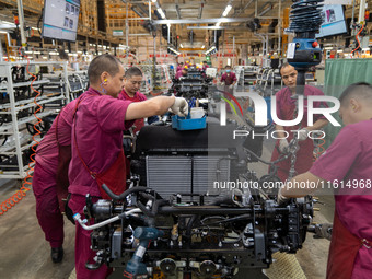 Workers work on a vehicle assembly line at a light truck workshop of Anhui Jianghuai Automobile Group Co LTD in Hefei, China, on September 2...