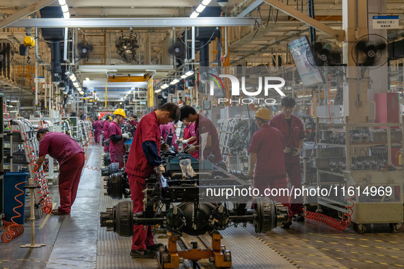 Workers work on a vehicle assembly line at a light truck workshop of Anhui Jianghuai Automobile Group Co LTD in Hefei, China, on September 2...