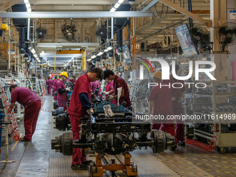 Workers work on a vehicle assembly line at a light truck workshop of Anhui Jianghuai Automobile Group Co LTD in Hefei, China, on September 2...