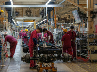 Workers work on a vehicle assembly line at a light truck workshop of Anhui Jianghuai Automobile Group Co LTD in Hefei, China, on September 2...