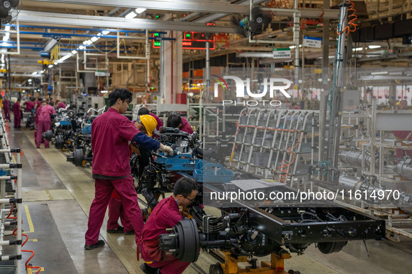 Workers work on a vehicle assembly line at a light truck workshop of Anhui Jianghuai Automobile Group Co LTD in Hefei, China, on September 2...