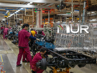 Workers work on a vehicle assembly line at a light truck workshop of Anhui Jianghuai Automobile Group Co LTD in Hefei, China, on September 2...