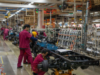 Workers work on a vehicle assembly line at a light truck workshop of Anhui Jianghuai Automobile Group Co LTD in Hefei, China, on September 2...