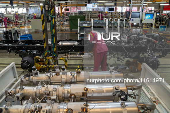 Workers work on a vehicle assembly line at a light truck workshop of Anhui Jianghuai Automobile Group Co LTD in Hefei, China, on September 2...