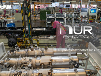 Workers work on a vehicle assembly line at a light truck workshop of Anhui Jianghuai Automobile Group Co LTD in Hefei, China, on September 2...