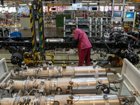 Workers work on a vehicle assembly line at a light truck workshop of Anhui Jianghuai Automobile Group Co LTD in Hefei, China, on September 2...