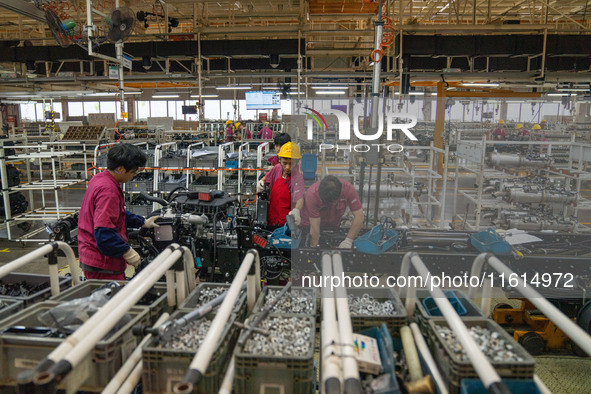 Workers work on a vehicle assembly line at a light truck workshop of Anhui Jianghuai Automobile Group Co LTD in Hefei, China, on September 2...