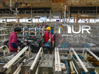 Workers work on a vehicle assembly line at a light truck workshop of Anhui Jianghuai Automobile Group Co LTD in Hefei, China, on September 2...