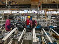 Workers work on a vehicle assembly line at a light truck workshop of Anhui Jianghuai Automobile Group Co LTD in Hefei, China, on September 2...