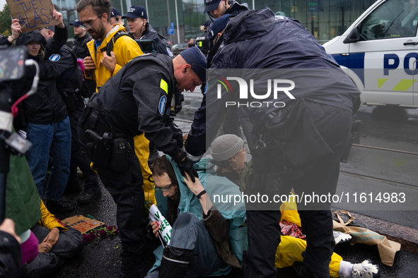 Activists from the environmental group Extinction Rebellion Finland ''Elokapina'' are arrested by the police during a protest in front of th...