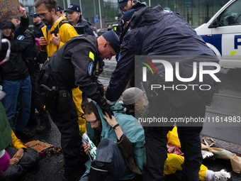 Activists from the environmental group Extinction Rebellion Finland ''Elokapina'' are arrested by the police during a protest in front of th...