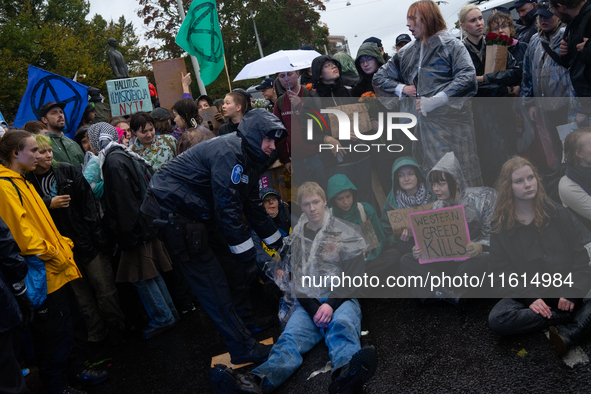 Activists from the environmental group Extinction Rebellion Finland ''Elokapina'' are arrested by the police during a protest in front of th...