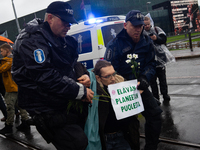 A police officer carries an activist from the environmental group Extinction Rebellion Finland ''Elokapina'' during a protest in front of th...