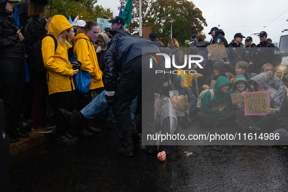 A police officer carries an activist from the environmental group Extinction Rebellion Finland ''Elokapina'' during a protest in front of th...