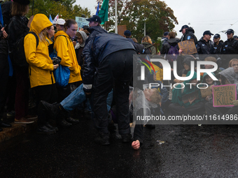 A police officer carries an activist from the environmental group Extinction Rebellion Finland ''Elokapina'' during a protest in front of th...