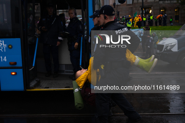 An activist from the environmental group Extinction Rebellion Finland ''Elokapina'' is arrested by the police during a protest in front of t...