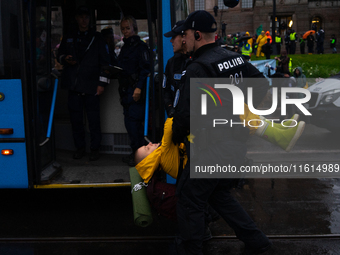 An activist from the environmental group Extinction Rebellion Finland ''Elokapina'' is arrested by the police during a protest in front of t...