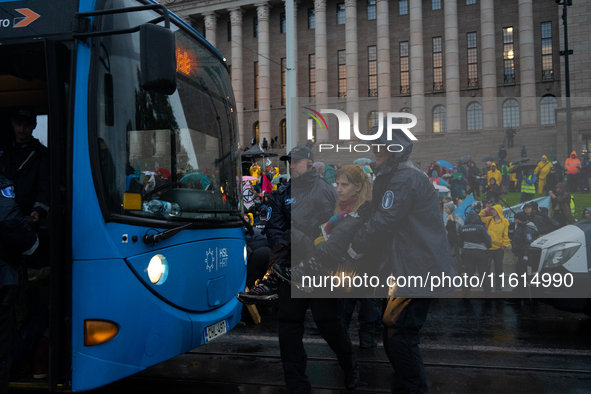 An activist from the environmental group Extinction Rebellion Finland ''Elokapina'' is arrested by the police during a protest in front of t...