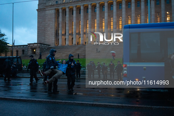 An activist from the environmental group Extinction Rebellion Finland ''Elokapina'' is arrested by the police during a protest in front of t...