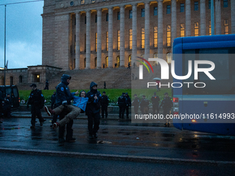 An activist from the environmental group Extinction Rebellion Finland ''Elokapina'' is arrested by the police during a protest in front of t...