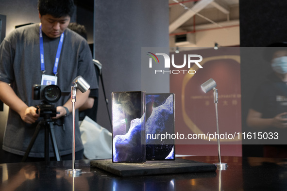 Customers experience a triple foldable phone at the Huawei exhibition area at WDCC2024 in Shanghai, China, on September 27, 2024. 