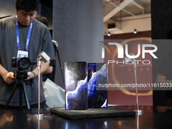 Customers experience a triple foldable phone at the Huawei exhibition area at WDCC2024 in Shanghai, China, on September 27, 2024. (