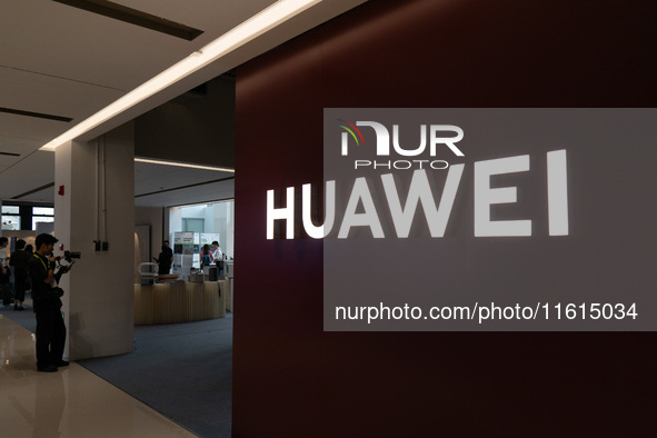 Customers experience a triple foldable phone at the Huawei exhibition area at WDCC2024 in Shanghai, China, on September 27, 2024. 