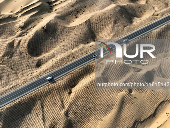 Vehicles drive on a desert highway in Bazhou, Xinjiang province, China, on September 23, 2024. (