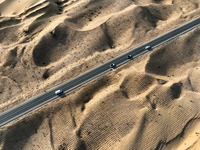 Vehicles drive on a desert highway in Bazhou, Xinjiang province, China, on September 23, 2024. (